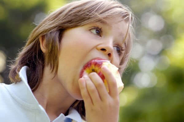 Boy eating apple outdoors