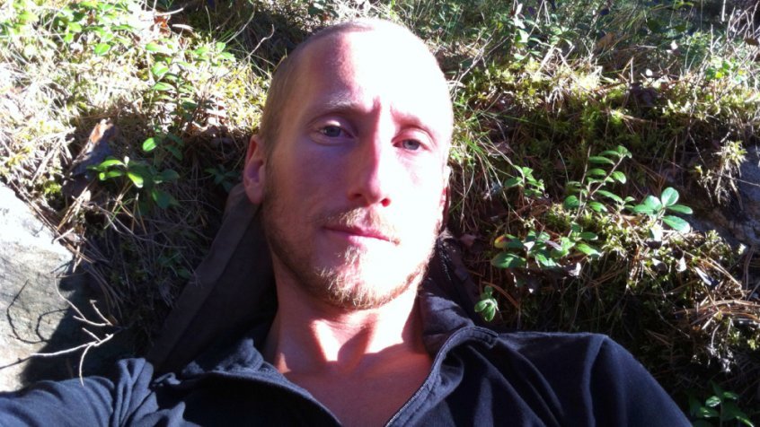 Raw Vegan Transformations - Rob Rehnmark laying in a field - Fruit-Powered