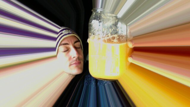 Victor VanRambutan holds an orange-colored smoothie in an effects photo