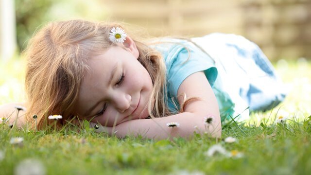 A young girl sleeps on grass