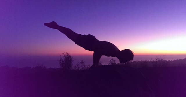 Conor McMillen, a.k.a. "Handy Man Bananas," balances while practicing yoga