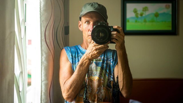 Mark Tassi photographs himself in a mirror in Cambodia