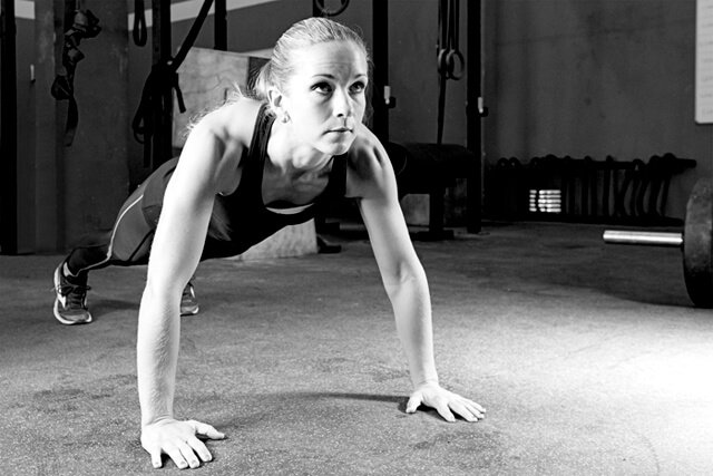 Young woman performing push-ups in a gymnasium