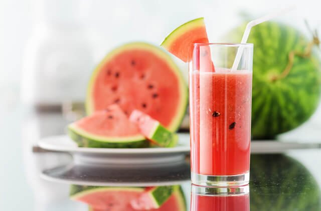 Whole and blended watermelon on a table