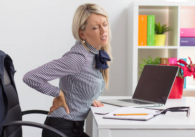 Woman rubs her achy back