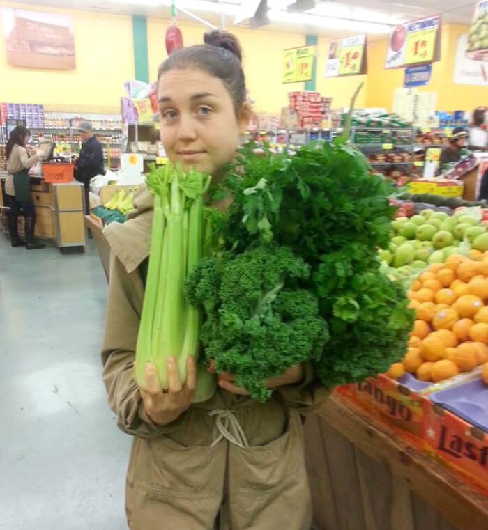 Aliyah Washington holds celery and other leafy greens