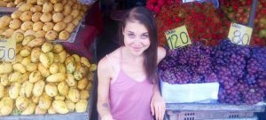 Aliyah Washington kneels beside fruits - Tips for Transitioning to a Raw Food Diet Intelligently