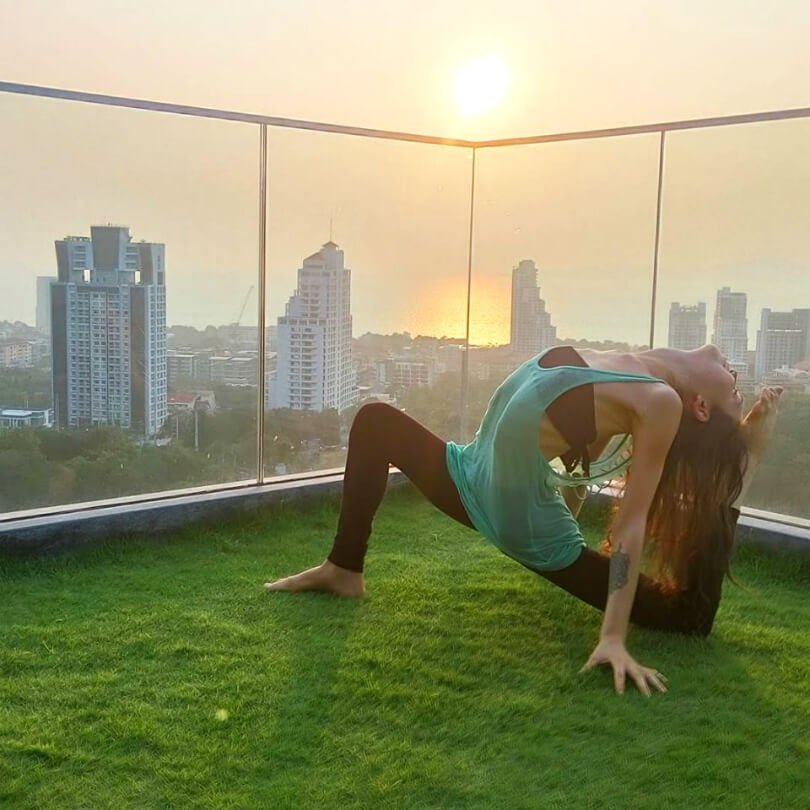 Aliyah Washington practices yoga on a building rooftop