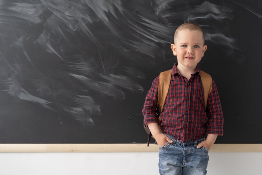 Forward head posture - schoolboy carrying backpack in classroom - Fruit-Powered